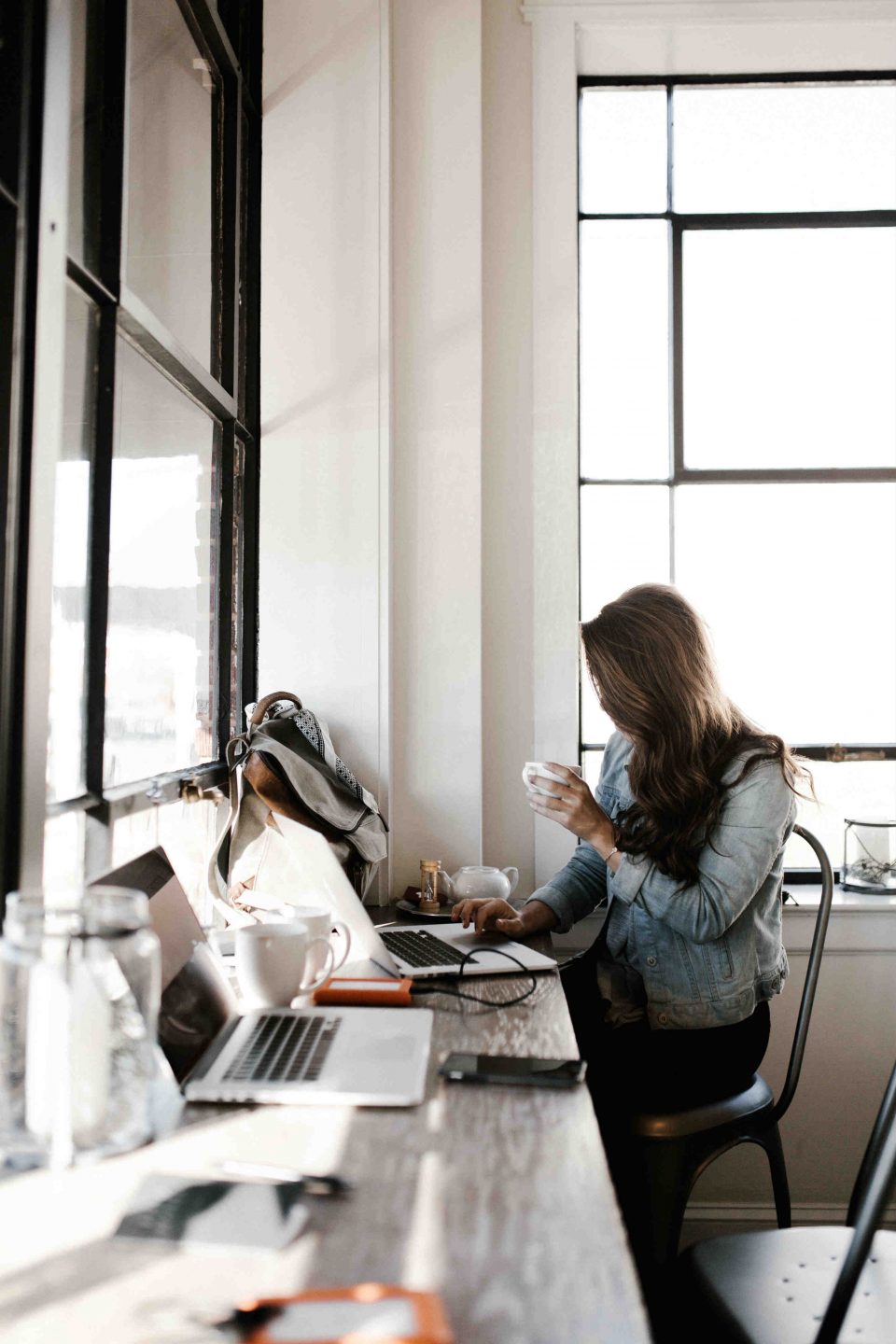 remote working e coronavirus immagine di copertina persona che lavora al computer bevendo un caffè